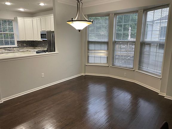Dining area next to kitchen with bay windows