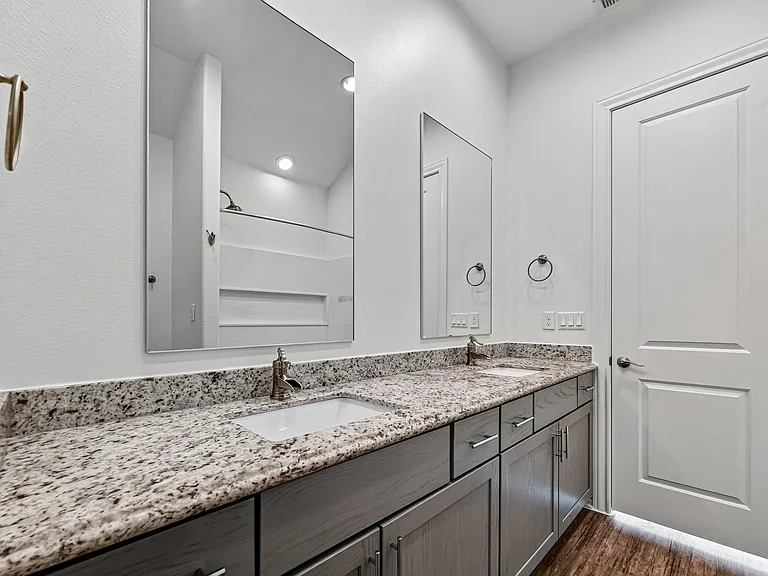 Primary ensuite bathroom featuring a double vanity.