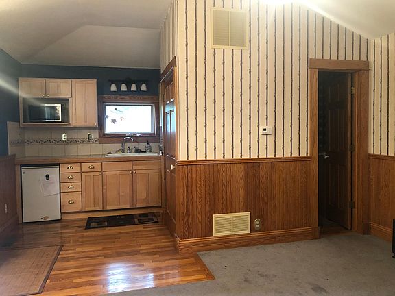 Kitchen area with door to a full bathroom. Facing west.