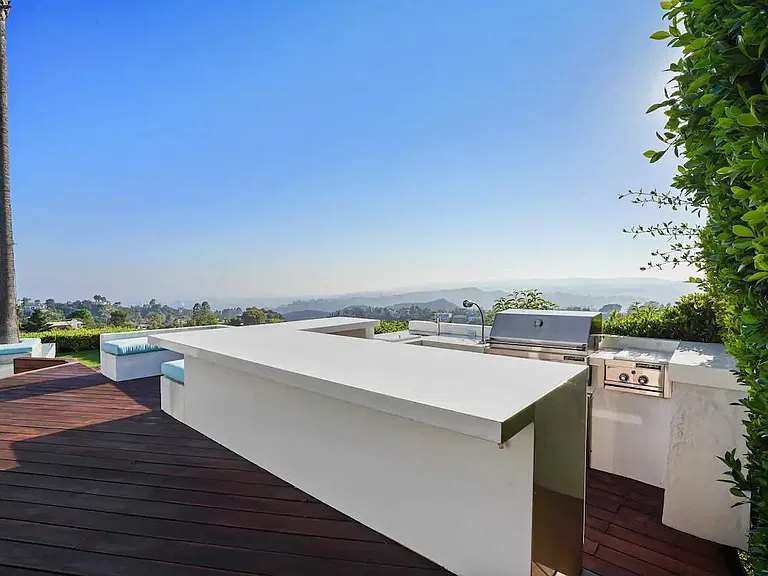 Entertain in style at the outdoor kitchen with a large counter, perfect for hosting memorable gatherings.