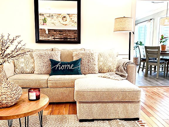 Enjoy cozy evenings on hardwood floors in front of a 55" TV, with serene views of the wooded, quiet backyard that bring a calm and relaxing feel to the space