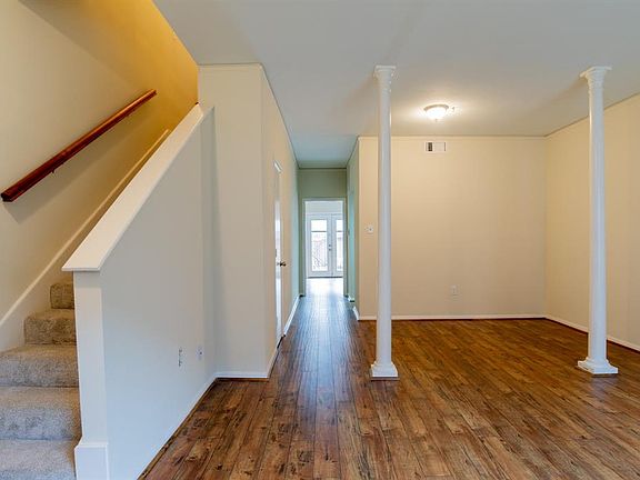 The wood flooring is carried throughout the downstairs. The kitchen is to the right, a storage closet is on the left and the den/3rd bedroom is at the rear of the hall.