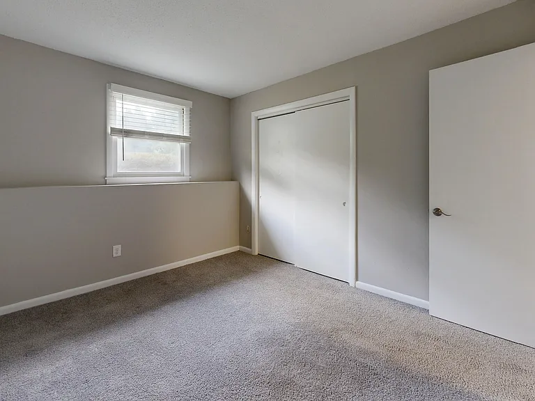This space features soft carpeting, a large window for natural light, and ample closet space for all your storage needs.