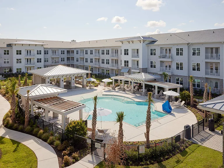 Zero Entry Salt Water Community Pool, located in a courtyard atmosphere surrounded by the apartment building. Outdoor kitchen. Lounge chairs.