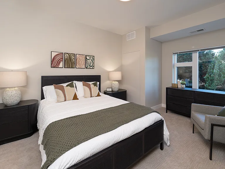 An airy bedroom designed with soft carpet and generous window space.