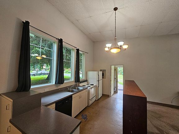 Kitchen equipped with dishwasher, stove, double sink and fridge.