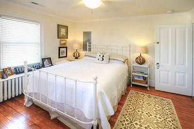 A bedroom with historic accents and lots of sunlight. Charming