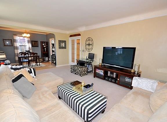 The bright and sunny, corner living room, with Southern and Eastern exposures, has covered hardwood 