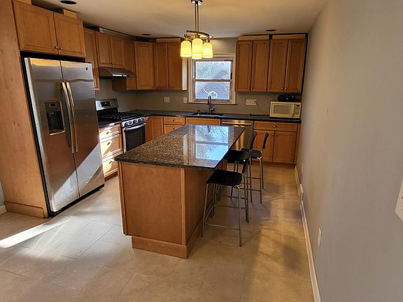 The remodeled eat-in kitchen has a center island and plenty of cabinet space.