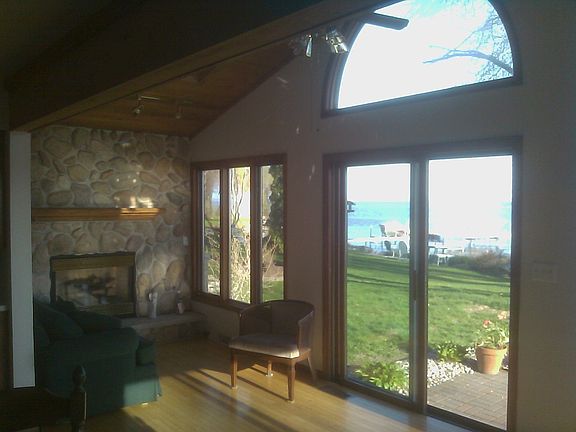 Sunroom with gas fireplace over looking lake