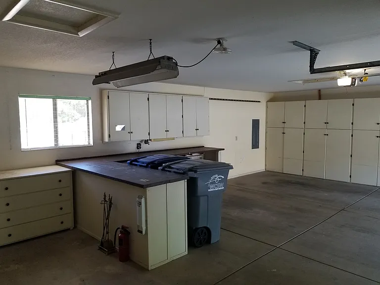 Large garage with storage and room for two cars, m/c, and equipment