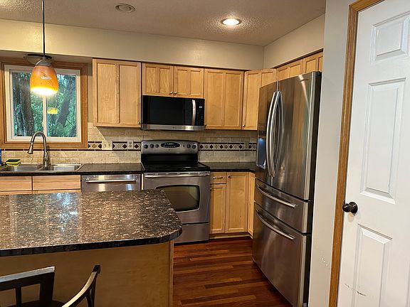 Kitchen with stainless steel refrigerator, stove/oven, microwave, dishwasher. Kitchen also has a pantry.