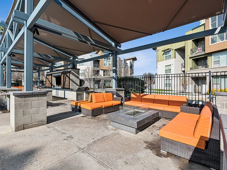 Aspire Apartments Tracy California Luxury Living A patio with black wicker furniture and orange cushions.