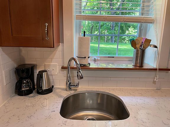 Quartz countertops, coffee pot, tea kettle, dishware, glassware, silverware.