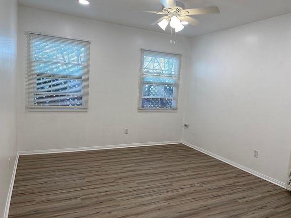 View of the living room as you walk into the unit showing new flooring, fan and lighting.