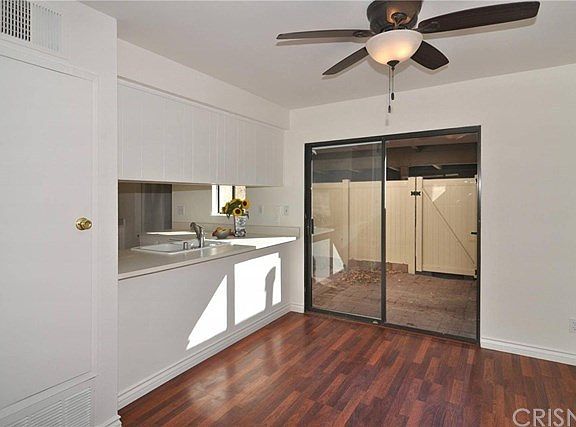 Laminate wood flooring in dining area with kitchen & patio access