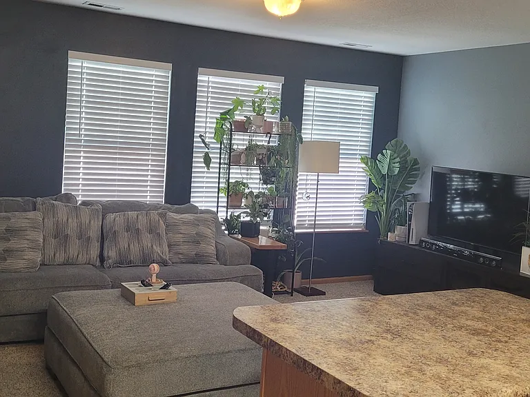 Kitchen island to living room with large sectional and ottoman.