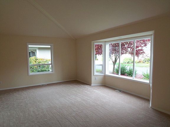 Large living room has vaulted ceiling and a bay window.