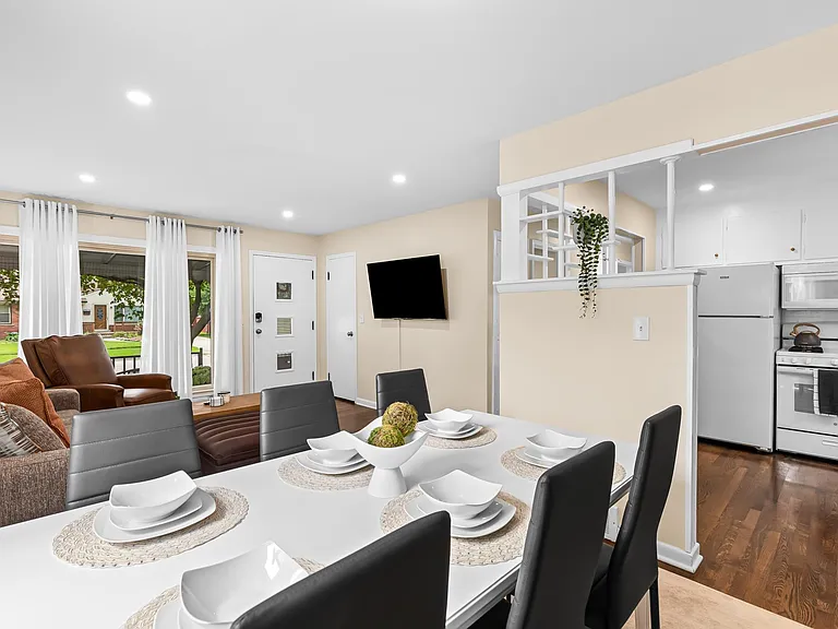The dining table is spacious enough to seat everyone comfortably, and the white dishes give the room a clean and modern look.