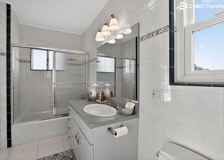 The upper level guest bathroom features a shower over tub