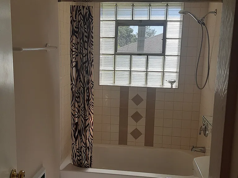 Scrunched Zebra curtain coordinates with tan & off-white ceramic tile