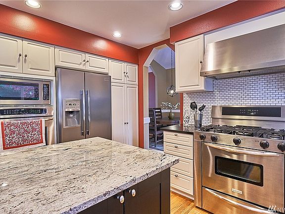 Stainless steel appliances include 5-burner gas range and two ovens