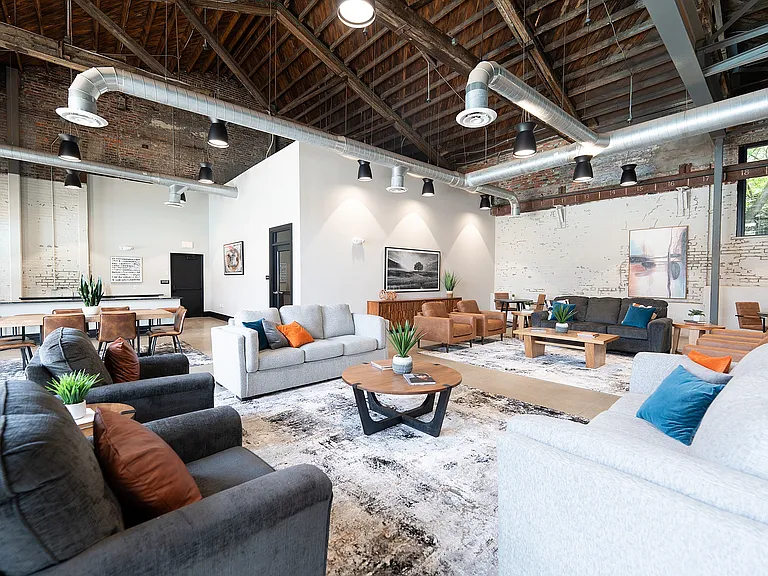 Modern loft-style dining and kitchen area with exposed brick