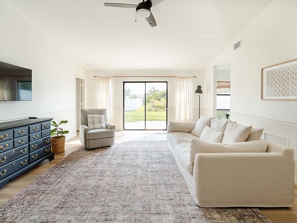 Living room with high ceilings and fan, with lots of natural light