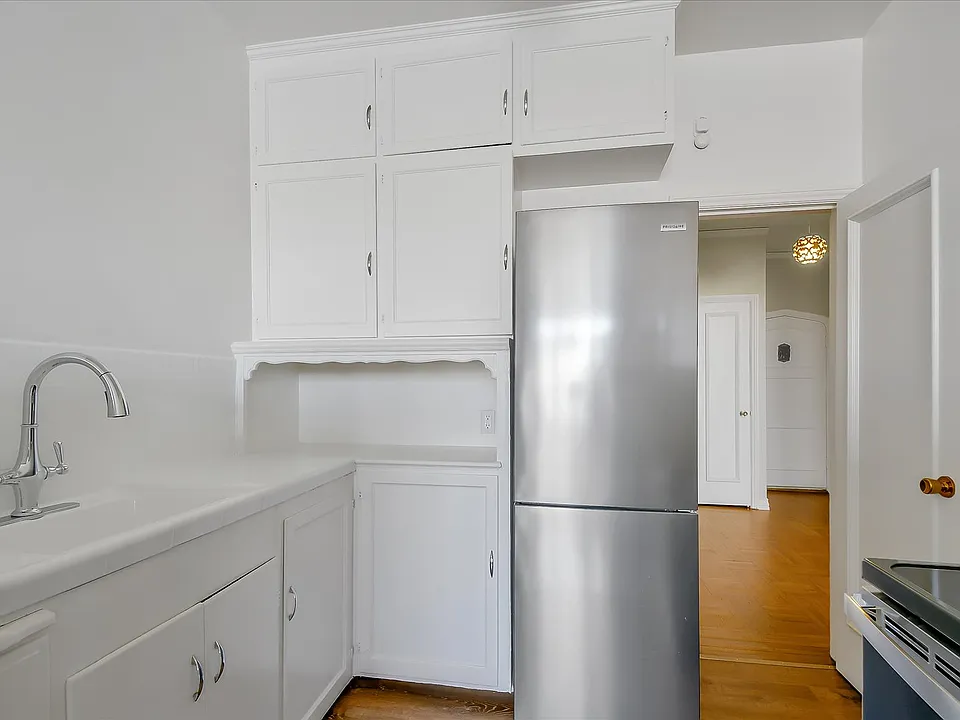 Kitchen 12' x 4'

Photos are from a different unit with the same layout. In the listed unit the countertops are vintage, original tile with all new grout, a different faucet, a brand-new but smaller fridge in white, and a similar glass top range in white.