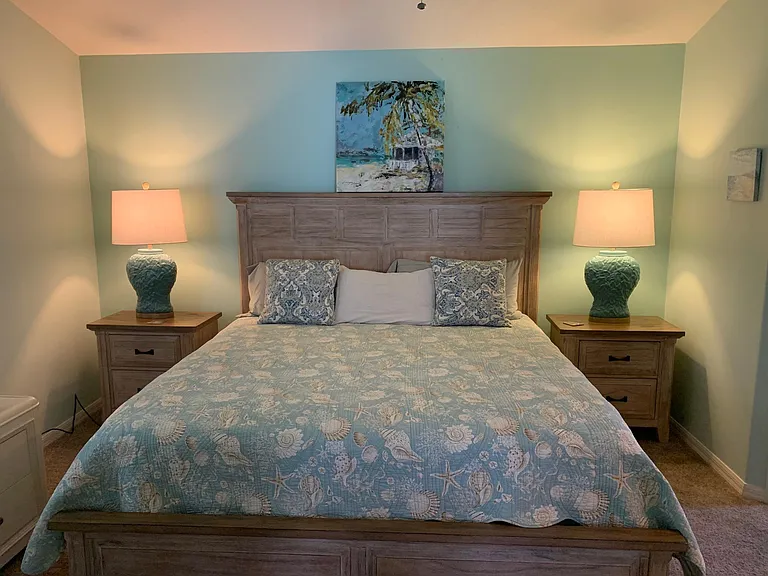 Primary suite with king size bed and vaulted ceiling.