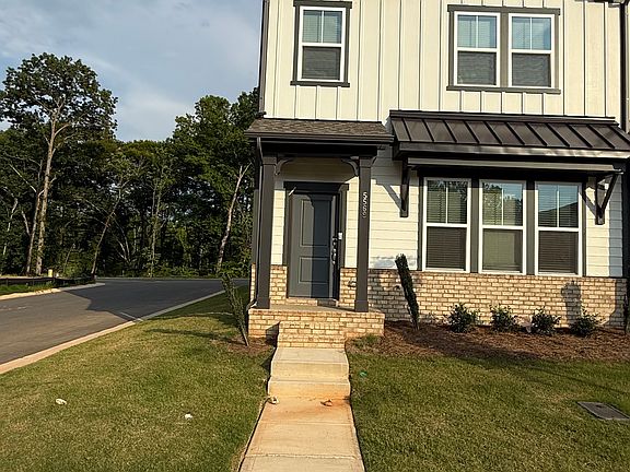 Beautiful modern townhome with covered front porch, two-car garage, and professionally landscaped exterior.