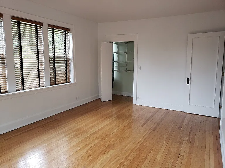 Main bedroom is 12 x 17 feet, six windows plus 7th window in the walk in closet with built in shelving, freshly painted, hardwood floors,