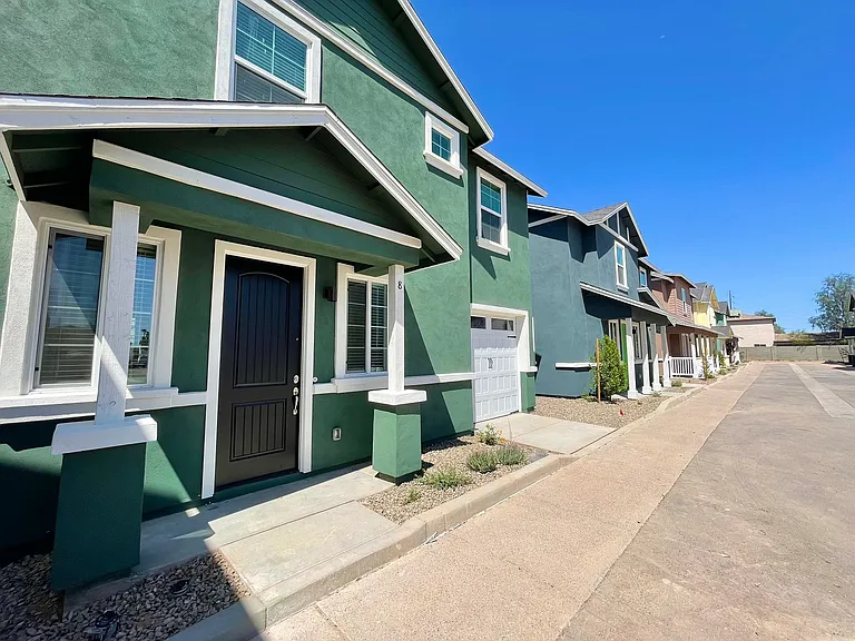 Another view of exterior of single family homes and drive.