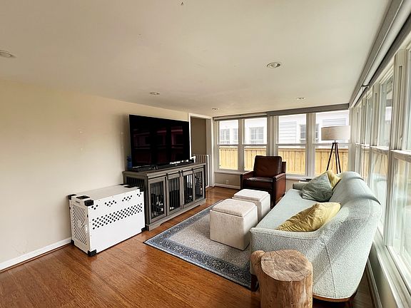 Cozy living room with lots of windows/natural light and a closet with built in shelving