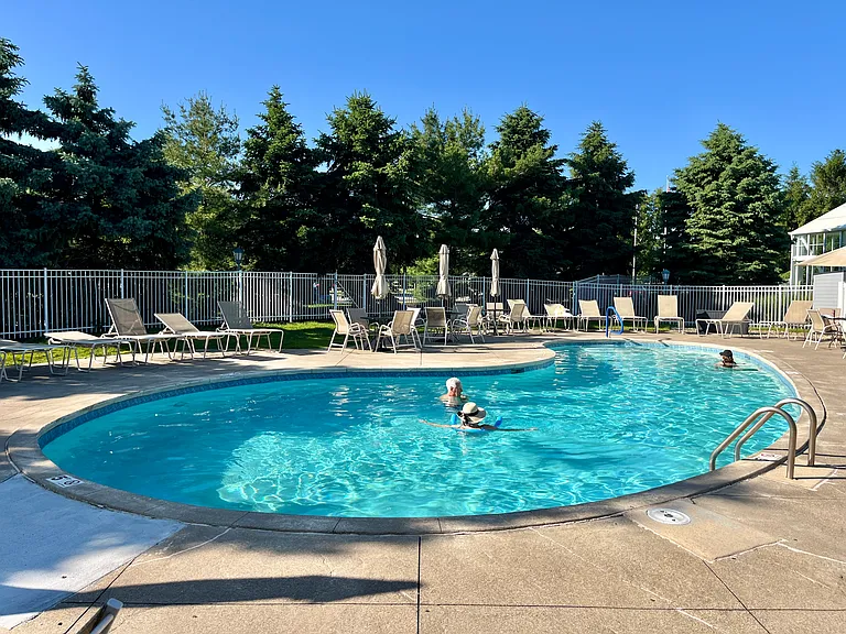 Outdoor Pool with Loungers and Umbrella Tables