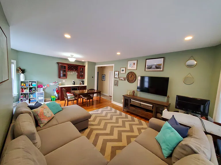 Living room and dining room area with wet bar and mini fridge