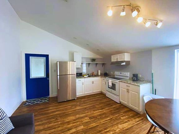 Spacious area featuring a cozy living room, dining space, and nearby kitchen.