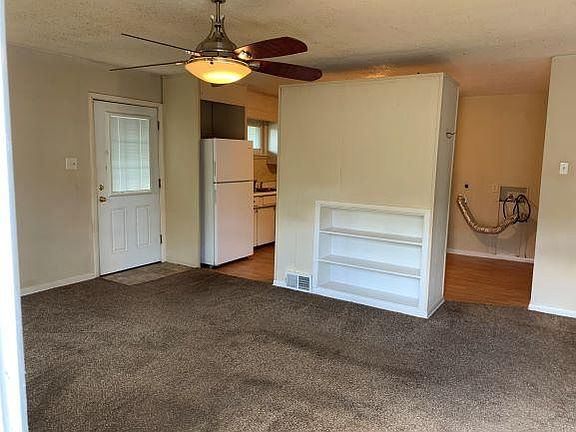 Living room to kitchen. Front door on left. Washer dryer area visible. Owner pays water bill.