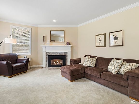 The formal living room is located off the entrance and features French doors and a gas fireplace.