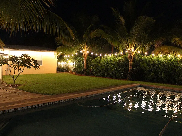Lights strung around entire backyard. Pavers are being professionally installed now. (House has been recently painted Navy)