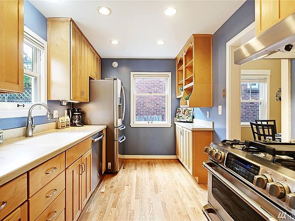 The kitchen with shaker cabinets and stainless appliances, including gas range.