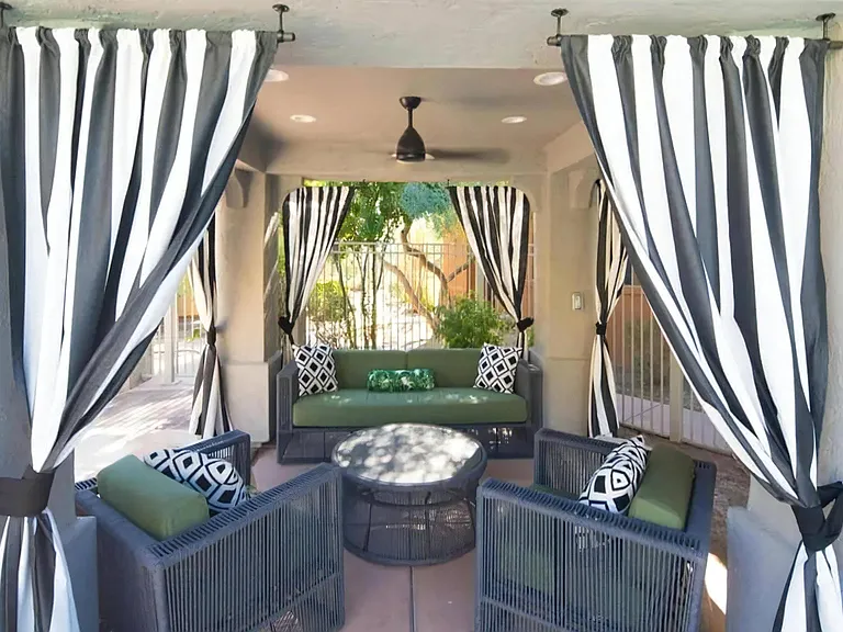 Shaded Outdoor Cabana with Lounge Seating and Privacy Curtains