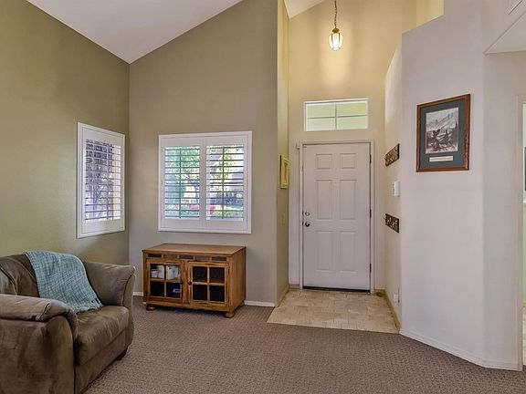 Front door. Living room area. Tile near entrance and carpet in living area.