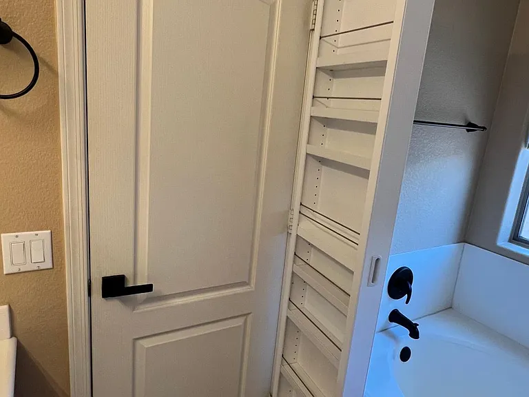 master bedroom's behind the door storage cabinet, swings open and stays shut by magnet