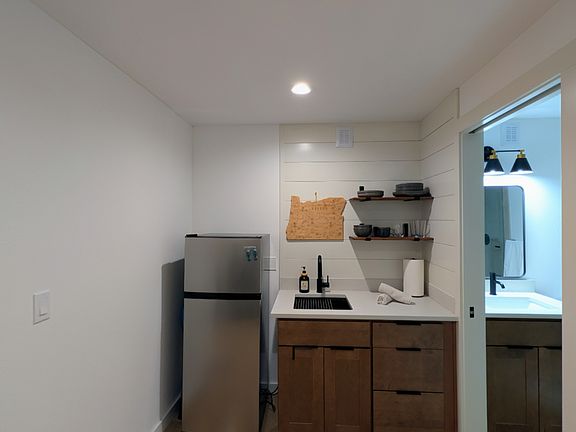 Private kitchenette with a refrigerator/freezer, plates, bowls, glasses, mugs, silverware, utensils, etc., and an electric induction cooktop.