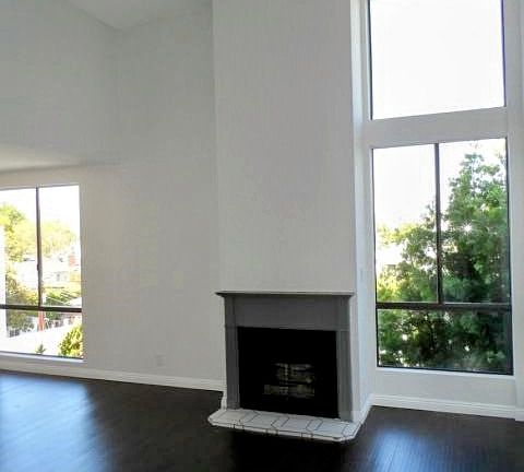 Living room with hardwood floors and amazing natural light.