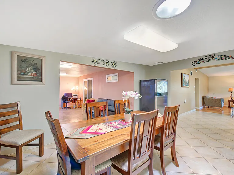 View of the dining room onto the family room (left) and parlor (right) in the distance. Fireplace is outside the frame, to the left.