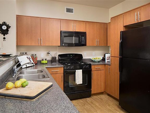 Cherry cabinetry, granite-look counters and sleek black appl
