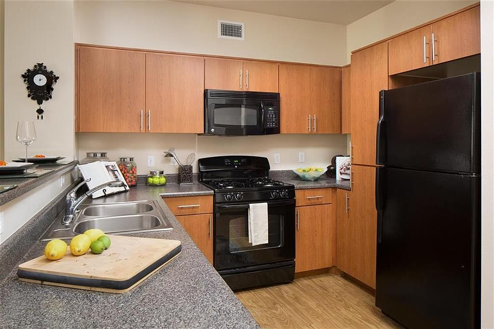 Cherry cabinetry, granite-look counters and sleek black appl