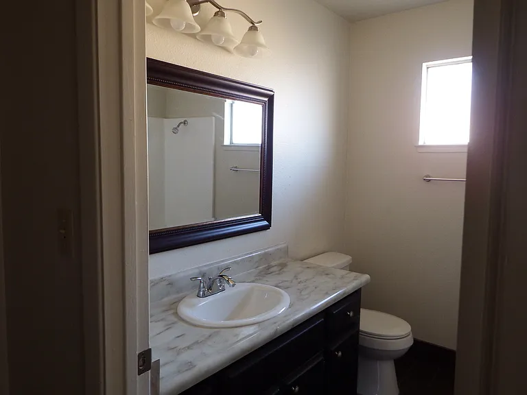 Upstairs full bathroom with updated lighting, large mirror over basin.